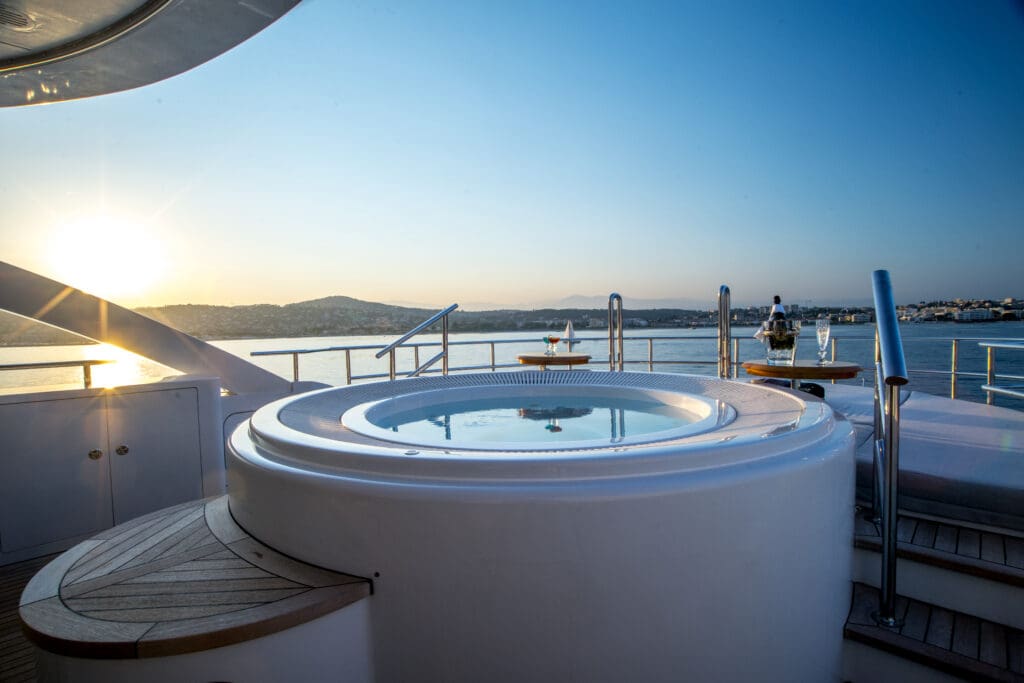 Hot tub on a yacht with sunset in the background.